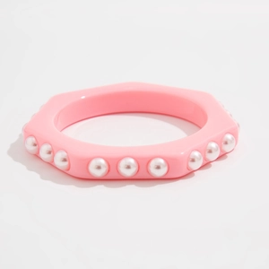 Detalle de brazalete hexagonal de resina rosa con perlas de imitación blancas
