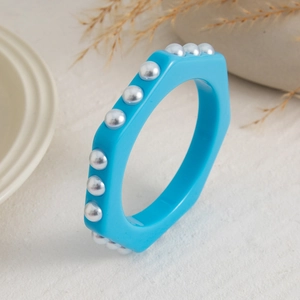 Vista detallada de la pulsera hexagonal de resina azul con detalles de perlas blancas