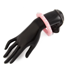 Vista detallada del brazalete de resina rosa con perlas sintéticas en soporte negro