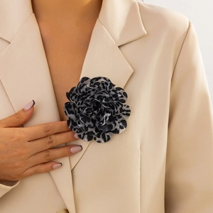 Dettaglio di spilla a fiore in tessuto leopardato su un risvolto di un blazer