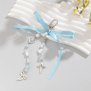 Détail du nœud en ruban bleu clair avec breloques argentées et perles pour sacs