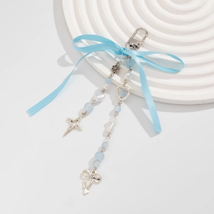 Porte-clés nœud bleu avec perles et breloques cœur sur un socle blanc