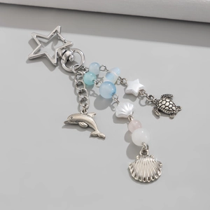 Detail of starfish clasp with dolphin, turtle, and shell charms on a marine keychain