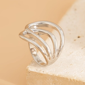 Close-up of silver layered liquid metal wave bracelet on a textured stone display