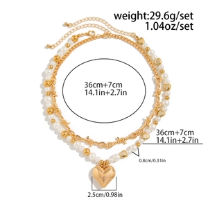 Detailed view of layered gold necklace dimensions with a large heart pendant and pearls