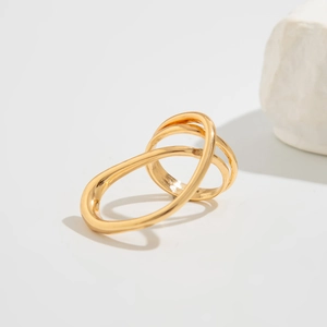 Detailaufnahme eines goldfarbenen Mehrschichtrings mit ineinandergreifenden Bändern