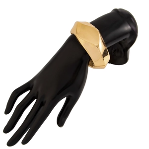 Detail of chunky gold geometric faceted bangle with glossy mirror finish on model