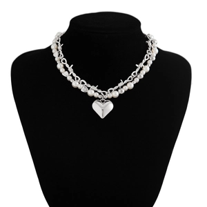Detail of double-layer necklace with pearls, silver thorn chain, and large heart pendant