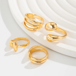 Macro detail of a 4-piece gold ring set featuring fluid aesthetics and geometric shapes
