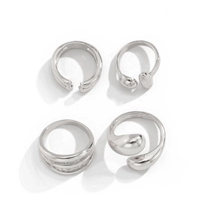 Close-up of four geometric silver rings featuring a minimalist liquid metal design