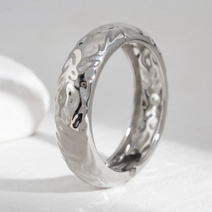 Detail view of the silver hammered texture and irregular wave finish on this wide bangle