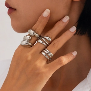Detail of silver liquid metal rings with irregular organic textures on model hand