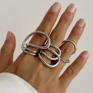 Dettaglio di anelli d'argento stile metallo liquido con design minimalista irregolare