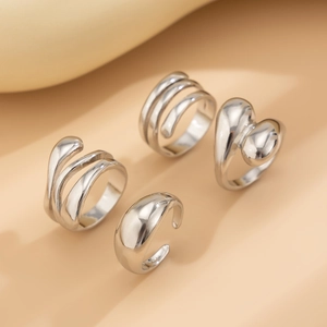 Detailed view of polished silver geometric rings set with abstract spiral and heart designs