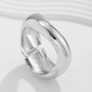 Dettaglio del bracciale rigido in metallo argento lucido con chiusura a molla