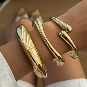 Three-piece set of gold minimalist teardrop open bracelets with a polished sculptural finish
