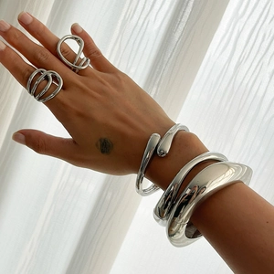 Minimalist irregular silver bangle and ring set featuring polished water-drop designs