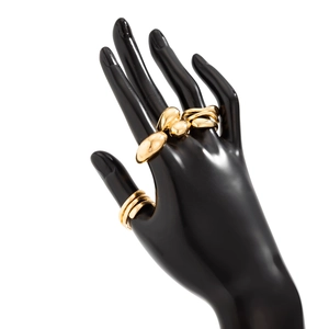 Bague dorée aux formes organiques et anneau triple épaisseur sur main de mannequin