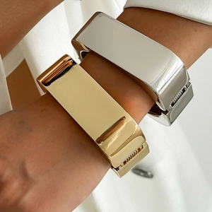 Onregelmatige brede armbandenset in goud en zilver met een gepolijst spiegeloppervlak