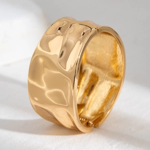Detail of wide liquid lava hammered gold cuff bracelet with irregular wavy texture