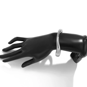 Detailaufnahme eines unregelmäßigen silbernen Metallarmreifs im minimalistischen Design