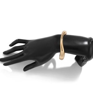 Detailaufnahme der polierten goldenen Wellenarmspange auf einem schwarzen Hand-Displaymodell