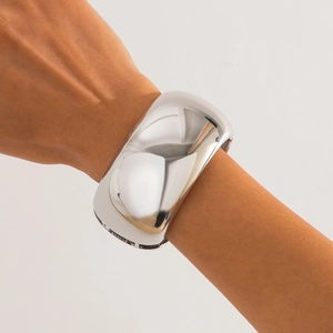 Close-up of a wide polished silver cuff bracelet with mirror finish on model wrist