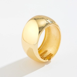 Detailed close-up of a wide gold metal bracelet featuring a polished hinge opening mechanism