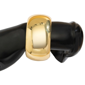 Macro view of wide geometric chunky metal cuff bracelet with polished gold finish