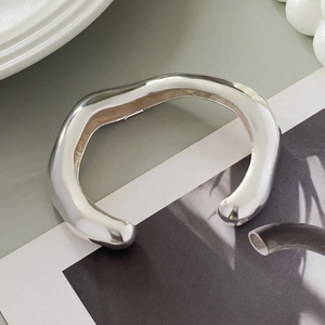 Close-up of irregular wave silver cuff bracelet with liquid metal finish and smooth texture