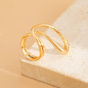 Macro detail of wave-shaped 18K gold-plated alloy ring showing fluid metallic texture