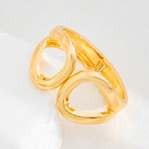 Detailed close-up of a golden hollow irregular geometric metal bangle with hinge design