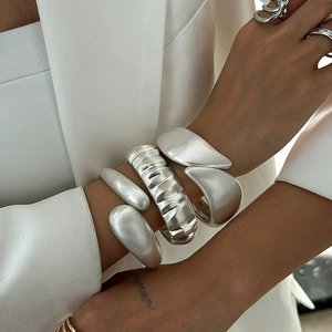 Minimalist matte silver chunky bracelet set with teardrop design and textured cuff on model
