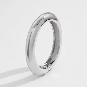 Macro detail of silver liquid metal bracelet featuring smooth hinge opening mechanism