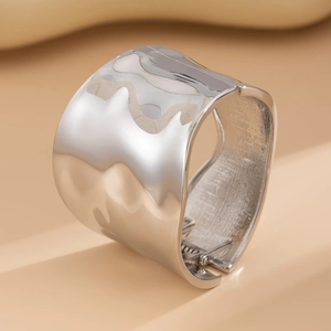 Macro shot of polished silver wavy cuff bracelet with inner spring hinge mechanism
