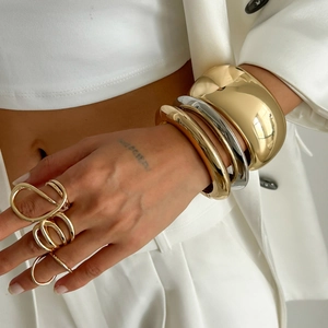 Exaggerated irregular metallic bracelets and rings set with gold and silver glossy finish