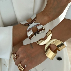 Minimalist geometric bangle and ring set with polished gold and silver finish on model
