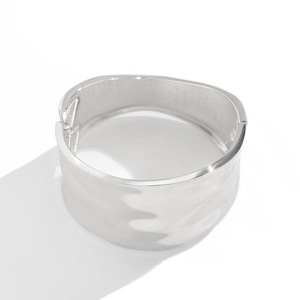 Detailed macro of silver hammered texture and hinge on wide metallic bangle bracelet