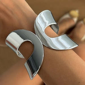 Detail of silver irregular C-shaped open bangle with high-polish mirror finish architecture