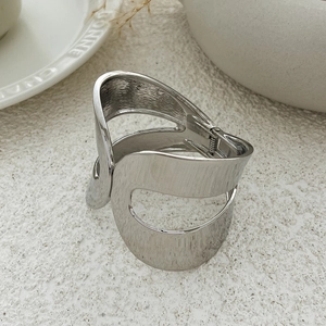 Detailed view of silver hollow geometric bangle with organic lines and hinge opening