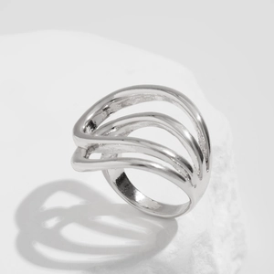 Macro detail of silver ring featuring a layered wavy hollow design on a white stone base