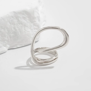 Macro detail of silver alloy bracelet featuring irregular wavy multi-layered organic design