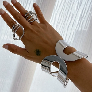 Polished silver irregular open bangle and matching rings set with minimalist design
