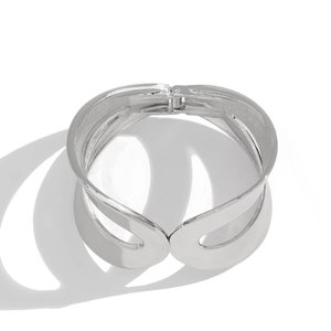 Polished silver wide open bangle featuring a modern overlapped curved design with hinge