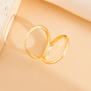Polished gold interlaced double ring with artistic wave design on textured stone surface