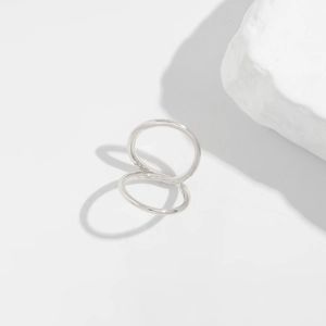 Detailed view of polished silver double-ring sculptural design with high-gloss finish