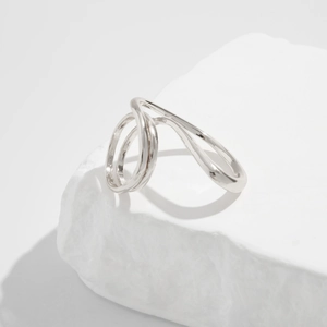 Close-up of silver minimalist geometric ring with dual-ring structure on white stone