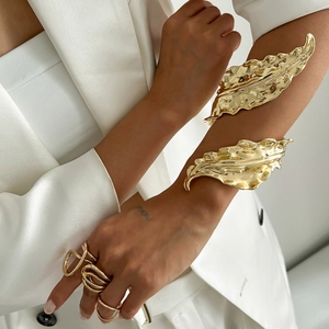 Golden liquid metal leaf cuff bracelet and irregular ring set on model in white suit