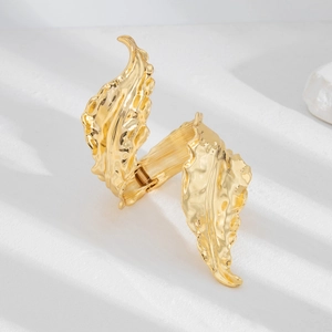 Macro detail of golden hammered texture on leaf-inspired liquid style metal bracelet