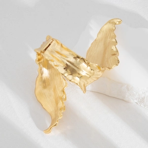 Detailed view of gold leaf bracelet showing brushed metal texture and spring hinge mechanism